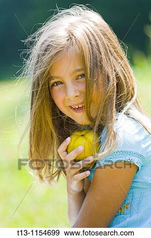 Six year old girl is holding a pear View Large Photo Image Stock Photo - Six year old girl is holding a pear. Fotosearch