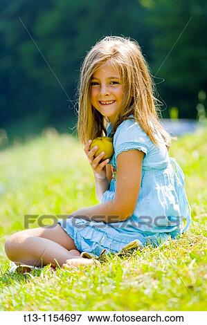 Six year old girl is laughing and holding a pear View Large Photo Image Stock Photo - Six year old girl is laughing and holding a pear. Fotosearch