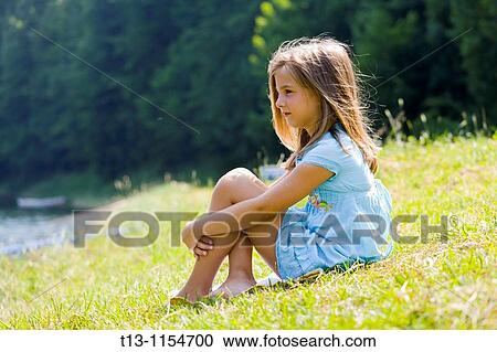 Six year old girl is sitting on a meadow View Large Photo Image Stock Image - Six year old girl is sitting on a meadow. Fotosearch
