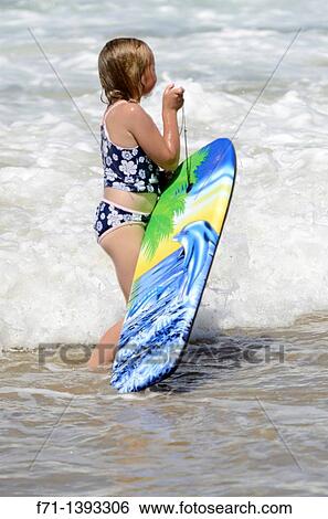 Six year old girl playing in the surf on a body board Mimiwhangata Northland, New Zealand View Large Photo Image Stock Photograph - Six year old girl playing in the surf on a body board Mimiwhangata Northland, New Zealand. Fotosearch