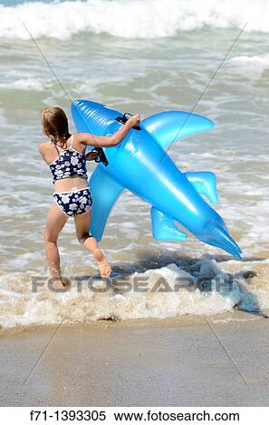 Six year old girl playing in the surf on inflatable shark Mimiwhangata Northland, New Zealand View Large Photo Image Stock Photography - Six year old girl playing in the surf on inflatable shark Mimiwhangata Northland, New Zealand. Fotosearch