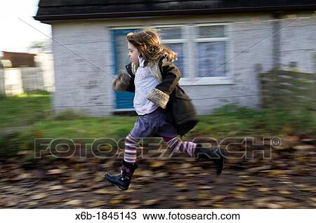 Six year old girl running along residential pavement covered in Autumn leaves View Large Photo Image Stock Image - Six year old girl running along residential pavement covered in Autumn leaves. Fotosearch