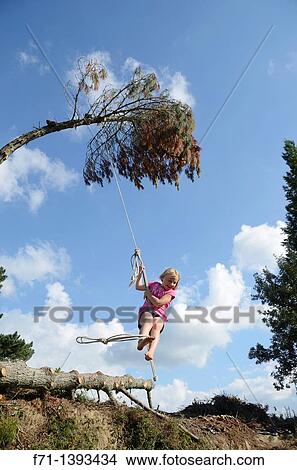 Six year old girl swinging on a rope swing Atiamuri, New Zealand View Large Photo Image Picture - Six year old girl swinging on a rope swing Atiamuri, New Zealand. Fotosearch