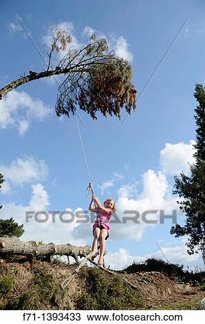 Stock Image - Six year old girl swinging on a rope swing Atiamuri, New Zealand. Fotosearch