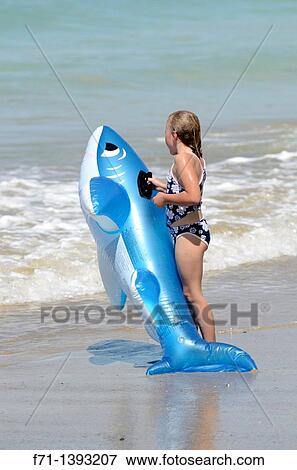 Six year old girld playing in the surf on inflatable shark Mimiwhangata Northland, New Zealand View Large Photo Image Stock Photo - Six year old girld playing in the surf on inflatable shark Mimiwhangata Northland, New Zealand. Fotosearch