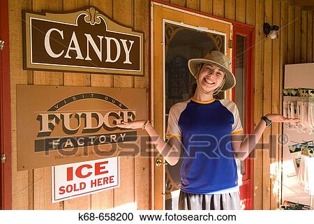 Stock Image - sixteen year old girl smiles outside candy store. Fotosearch