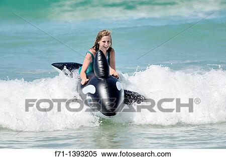 Sixteen year old girld playing in the surf with inflatable Orca Mimiwhangata Northland, New Zealand View Large Photo Image Stock Photography - Sixteen year old girld playing in the surf with inflatable Orca Mimiwhangata Northland, New Zealand. Fotosearch