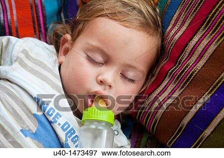 Stock Photo - Sleeping boy with bottle. Fotosearch