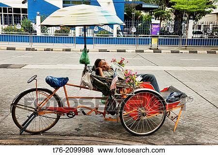 sleeping in a becak (trishaw) in Georgetown in Penang, Malaysia. View Large Photo Image Stock Photo - sleeping in a becak (trishaw) in Georgetown in Penang, Malaysia.. Fotosearch