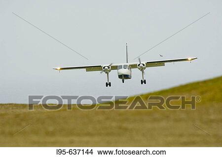 Small aircraft shuttle between Shetland islands landing at Fair Isle landing ground View Large Photo Image Picture - Small aircraft shuttle between Shetland islands landing at Fair Isle landing ground. Fotosearch