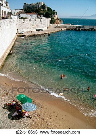 Stock Image - Small beach next to the sea defences of the town of Gibraltar.. Fotosearch