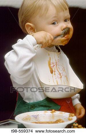 Picture - Small boy aged 3 eating baked beans.. Fotosearch