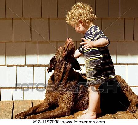 Stock Photo - Small boy and his dog looking at each other.. Fotosearch