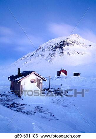 Stock Photograph - Small cabins and a moutain called? N Sytertoppen?, in blue morning light. Syterskalet. Lapland. Sweden.. Fotosearch