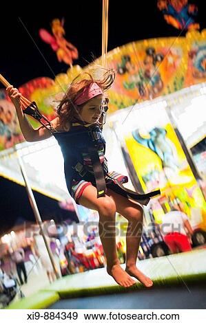 Stock Photo - Small Child on Bungy Trampoline. Town of Sanlucar de Barrameda, province of Cadiz, Andalusia, Spain.. Fotosearch
