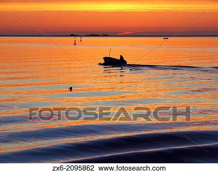 Small fishing boat at dawn, sailing across Alfacs Bay, Ebro Delta Natural Park. Sant Carles de la Rapita Village. Montsia Region, Tarragona Province, Catalonia, Spain. View Large Photo Image Stock Image - Small fishing boat at dawn, sailing across Alfacs Bay, Ebro Delta Natural Park. Sant Carles de la Rapita Village. Montsia Region, Tarragona Province, Catalonia, Spain.. Fotosearch