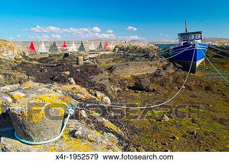 Small fishing boat resting on its keel at low tide on Lettermore Island, County Galway, Ireland. View Large Photo Image Stock Photo - Small fishing boat resting on its keel at low tide on Lettermore Island, County Galway, Ireland.. Fotosearch
