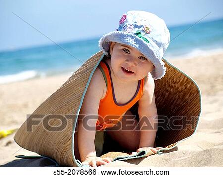 Stock Photograph - Small girl playing on the beach, Tarragona, Catalonia, Spain.. Fotosearch