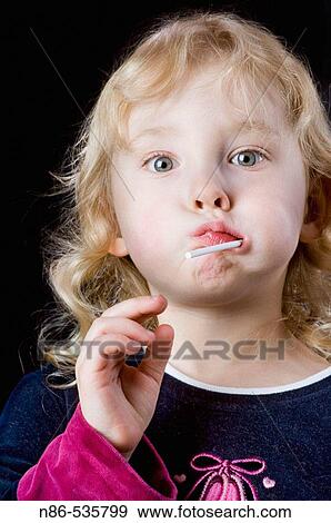 Small girl sucking on a lolly pop View Large Photo Image Stock Photo - Small girl sucking on a lolly pop. Fotosearch