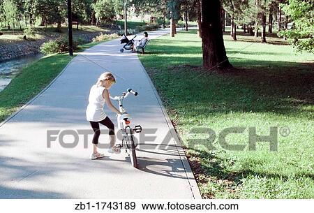 Small girl with bike in the park View Large Photo Image Stock Photo - Small girl with bike in the park. Fotosearch