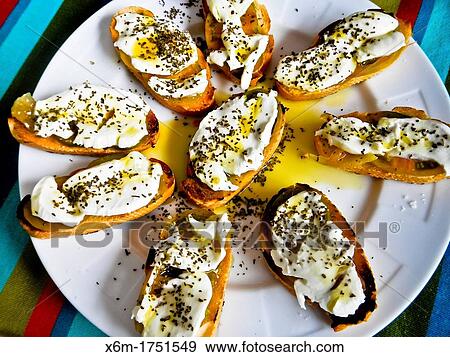 Stock Photo - small portions of bread with tomato, olive oil, mozzarella cheese and oregano herb. Fotosearch