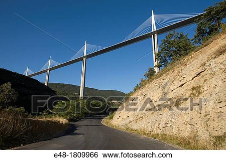 SMALL ROAD UNDER VIADUCT DE MILLAU AUTOROUTE 75 LA MERIDIEE MASSIF CENTRAL AVEYRON FRANCE View Large Photo Image Stock Photograph - SMALL ROAD UNDER VIADUCT DE MILLAU AUTOROUTE 75 LA MERIDIEE MASSIF CENTRAL AVEYRON FRANCE. Fotosearch