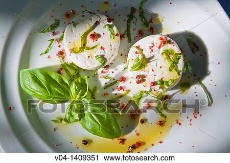 Small round goats cheeses with basil and red pepper on a white plate View Large Photo Image Stock Image - Small round goats cheeses with basil and red pepper on a white plate. Fotosearch