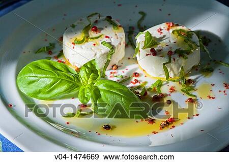 Small round goats cheeses with basil and red pepper on a white plate View Large Photo Image Stock Photo - Small round goats cheeses with basil and red pepper on a white plate. Fotosearch
