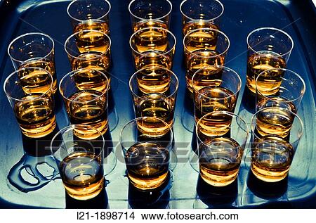 Small vessel set filled with an alcoholic beverage on a tray. View Large Photo Image Picture - Small vessel set filled with an alcoholic beverage on a tray.. Fotosearch