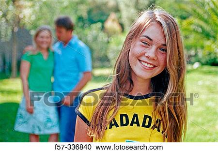 Smiley girl with parents at background View Large Photo Image Stock Image - Smiley girl with parents at background. Fotosearch