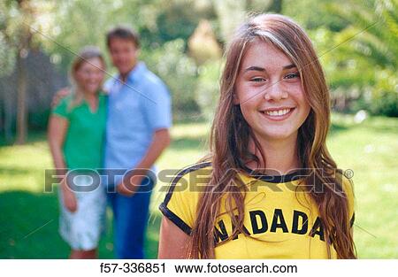 Smiley girl with parents at background View Large Photo Image Stock Image - Smiley girl with parents at background. Fotosearch