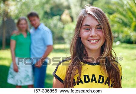 Smiley girl with parents at background View Large Photo Image Stock Photograph - Smiley girl with parents at background. Fotosearch