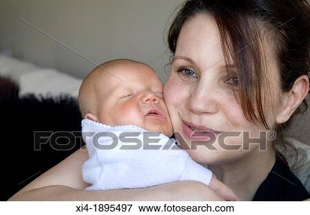 Smiley mother hugging newborn View Large Photo Image Stock Photo - Smiley mother hugging newborn. Fotosearch
