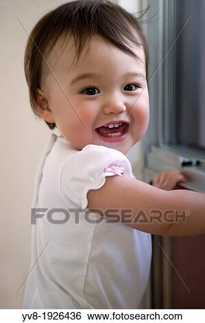 Smiling baby in front of a window View Large Photo Image Stock Photograph - Smiling baby in front of a window. Fotosearch