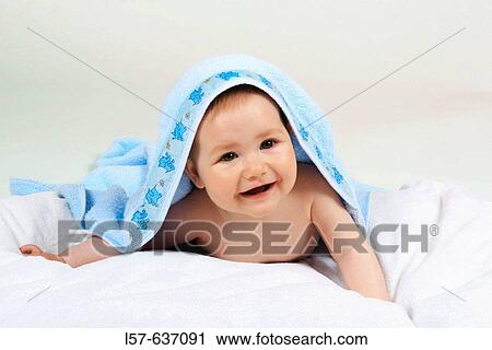 Stock Image - smiling Baby with bathtowl, lying on tummy, Studio, Oetwil am See, Zuerich, Schweiz. Fotosearch