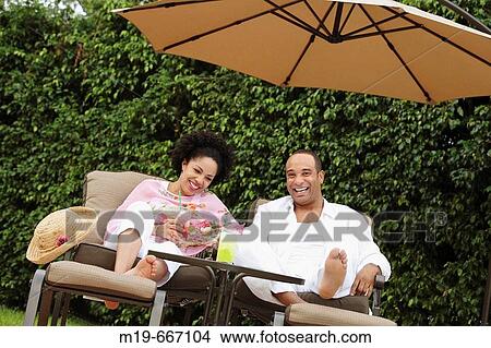 Smiling couple laughing poolside View Large Photo Image Picture - Smiling couple laughing poolside. Fotosearch