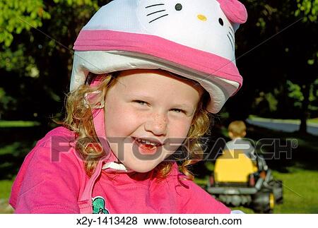 Stock Photo - Smiling five year old girl with bike safety helmet. Fotosearch