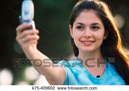 Smiling for her digital camera phone View Large Photo Image Stock Image - Smiling for her digital camera phone. Fotosearch