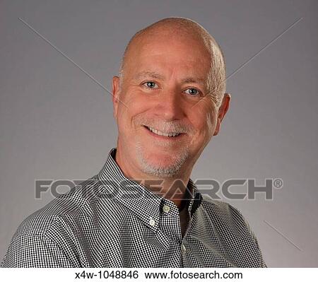 Stock Photograph - Smiling, friendly middle aged bald man with goatee looking at camera. Fotosearch