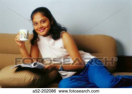 Stock Photograph - Smiling girl having tea. Fotosearch