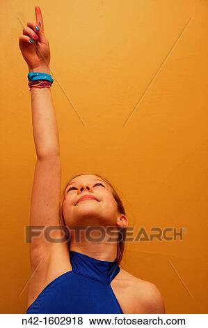 Smiling girl points upward View Large Photo Image Stock Photo - Smiling girl points upward. Fotosearch