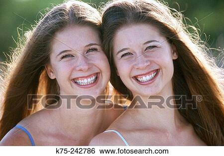 Smiling identical twins View Large Photo Image Stock Photograph - Smiling identical twins. Fotosearch