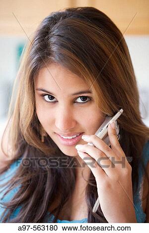 Smiling latina teen girl using her cellphone. View Large Photo Image Stock Image - Smiling latina teen girl using her cellphone.. Fotosearch