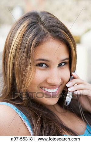 Smiling latina teen girl using her cellphone. View Large Photo Image Stock Image - Smiling latina teen girl using her cellphone.. Fotosearch