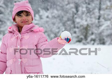 Smiling little girl holding snowball View Large Photo Image Stock Photograph - Smiling little girl holding snowball. Fotosearch