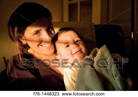 Smiling mother holding her one year old son, cuddling with blanket View Large Photo Image Stock Image - Smiling mother holding her one year old son, cuddling with blanket. Fotosearch