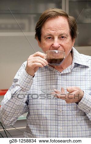 smiling senior man holding a cup of coffee in one hand and a saucer in the other hand about to drink coffee View Large Photo Image Picture - smiling senior man holding a cup of coffee in one hand and a saucer in the other hand about to drink coffee. Fotosearch