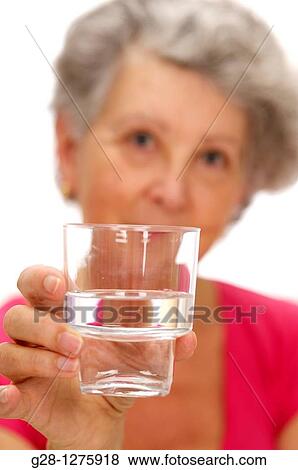 smiling senior woman holding a glass of water View Large Photo Image Stock Photo - smiling senior woman holding a glass of water. Fotosearch