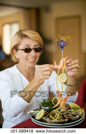 Smiling woman with sunglasses eating seafood. Brittany, France View Large Photo Image Stock Photo - Smiling woman with sunglasses eating seafood. Brittany, France. Fotosearch