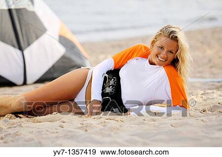 Smiling young blonde woman lying on the beach View Large Photo Image Stock Photo - Smiling young blonde woman lying on the beach. Fotosearch